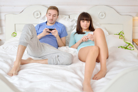 couple-on-smartphones-in-bed